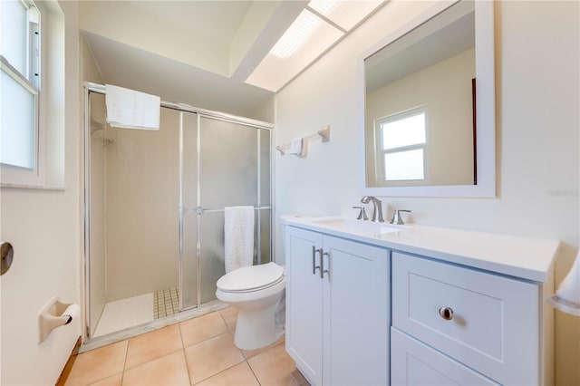 bathroom with a shower with shower door, vanity, toilet, and tile patterned floors