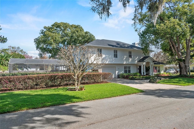 view of front of home with a garage, driveway, a front lawn, and stucco siding