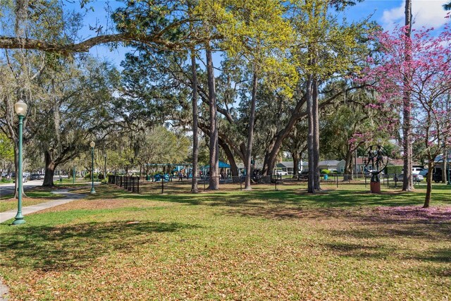 view of property's community featuring a lawn and fence