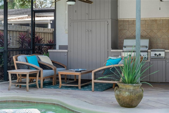 view of patio with a grill, fence, and area for grilling