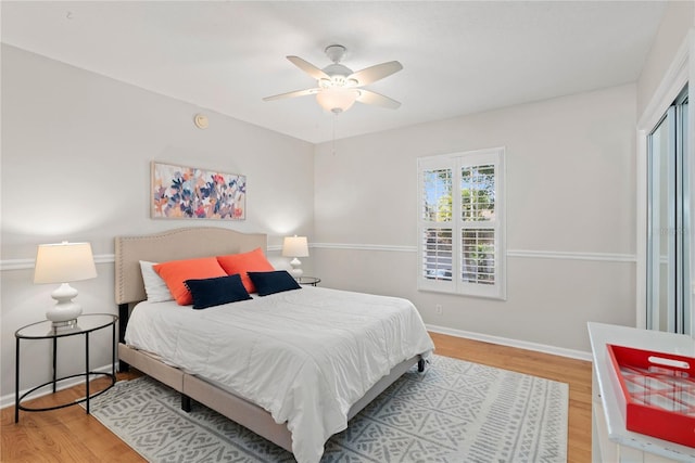 bedroom with a ceiling fan, a closet, baseboards, and wood finished floors