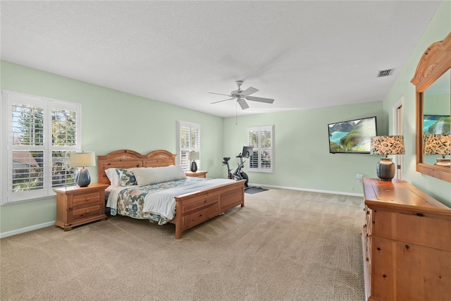 bedroom featuring a ceiling fan, baseboards, visible vents, and carpet flooring