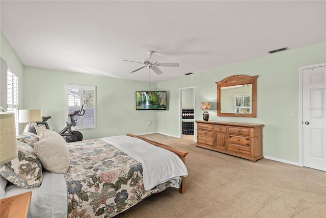 bedroom featuring light carpet, baseboards, multiple windows, and visible vents