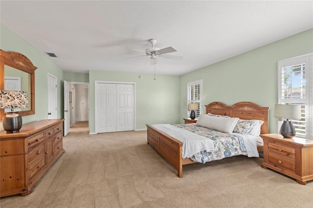 bedroom with ceiling fan, visible vents, and light colored carpet