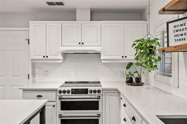 kitchen featuring white cabinets, under cabinet range hood, visible vents, and range with two ovens