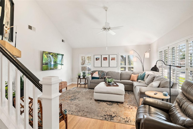 living room with visible vents, a ceiling fan, stairway, wood finished floors, and high vaulted ceiling