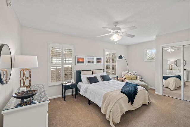 bedroom with light colored carpet, ceiling fan, and baseboards