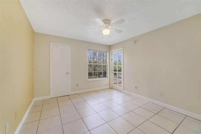 tiled empty room with ceiling fan and a textured ceiling