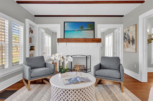 sitting room featuring hardwood / wood-style floors, crown molding, and a fireplace