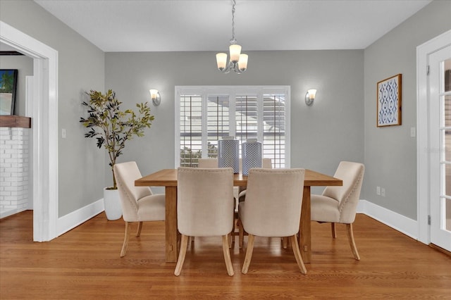 dining room with hardwood / wood-style floors and a notable chandelier