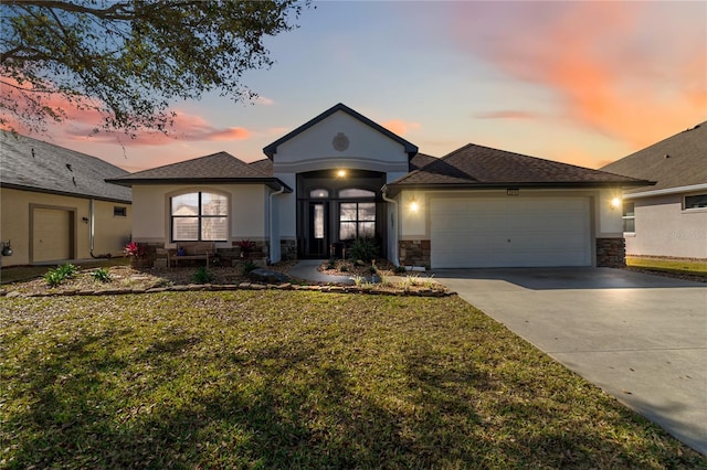 prairie-style home with a garage and a yard