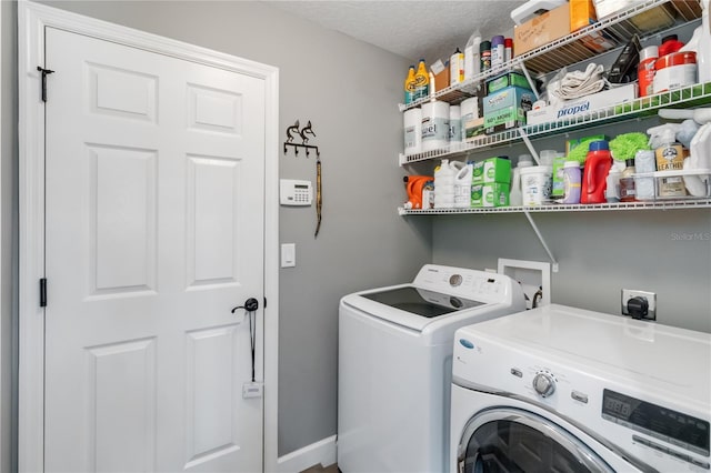 washroom with a textured ceiling and washing machine and clothes dryer