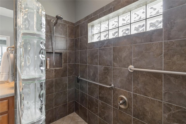 bathroom featuring a tile shower and vanity