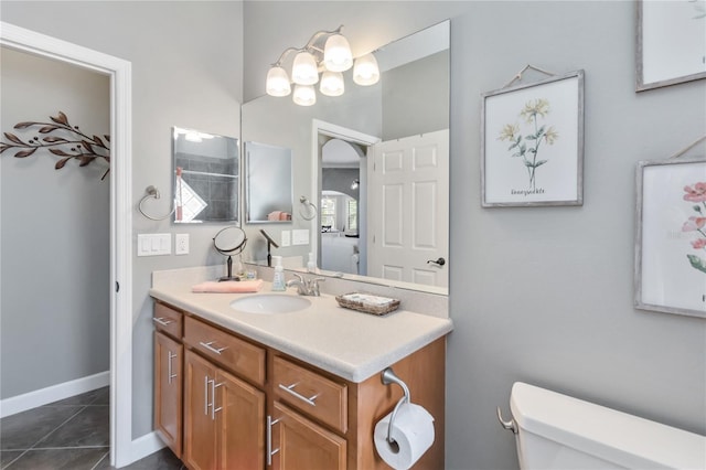 bathroom with toilet, tile patterned flooring, and vanity