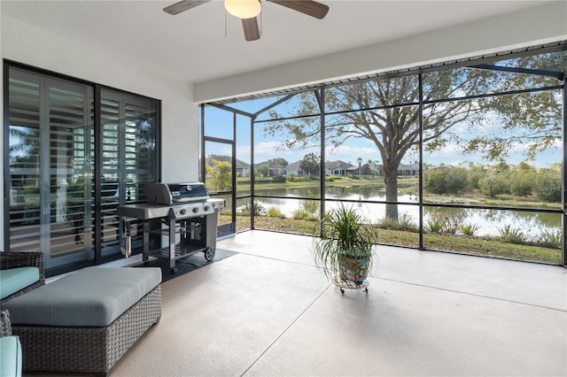 sunroom with a water view and ceiling fan