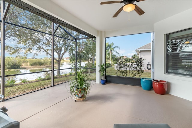 sunroom / solarium with a water view and ceiling fan