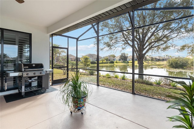 sunroom featuring a water view