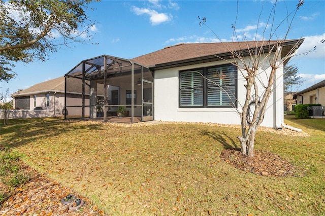 back of property with a yard, central air condition unit, and glass enclosure