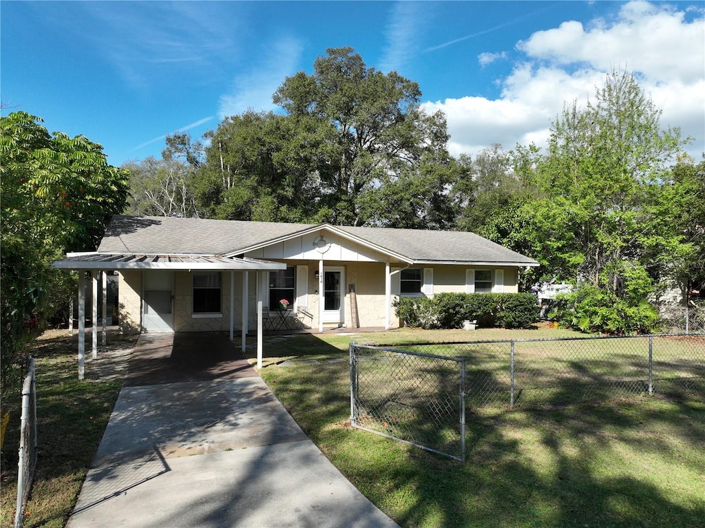 ranch-style house with covered porch, a carport, and a front yard