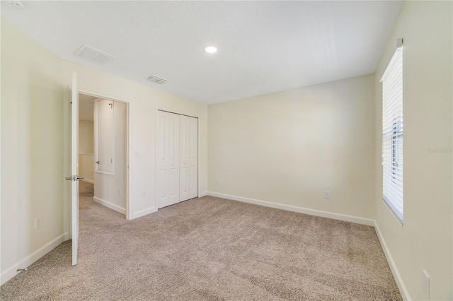 15088 Night Heron Dr, Winter Garden, FL 34787 - unfurnished bedroom featuring carpet flooring, multiple windows, a closet, and recessed lighting
