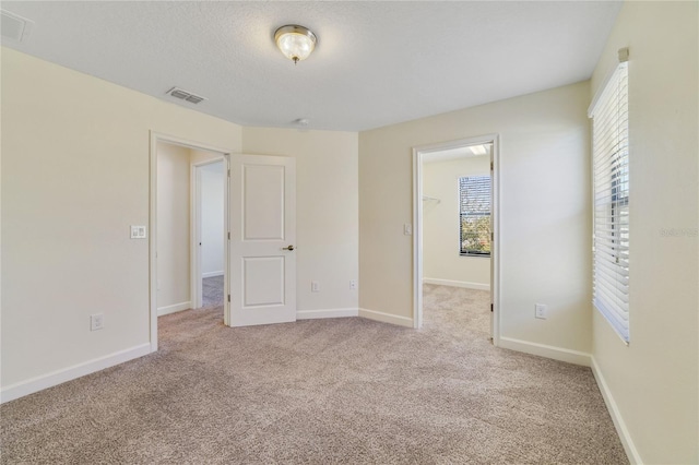 15088 Night Heron Dr, Winter Garden, FL 34787 - unfurnished bedroom with multiple windows, light carpet, and a walk in closet