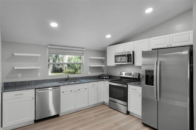 kitchen with sink, lofted ceiling, white cabinetry, and stainless steel appliances