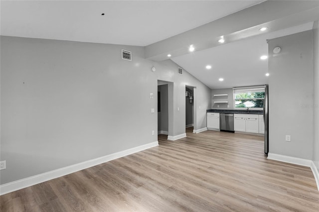 unfurnished living room featuring sink, light wood-type flooring, and lofted ceiling