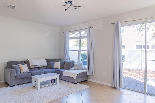 living room with light tile patterned floors, visible vents, and baseboards