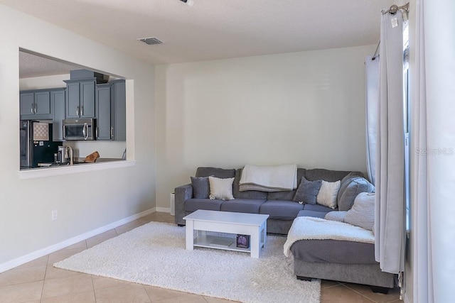 living area featuring visible vents, baseboards, and tile patterned floors