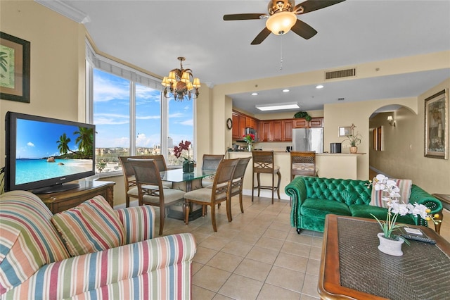 living area with arched walkways, light tile patterned flooring, recessed lighting, ceiling fan with notable chandelier, and visible vents