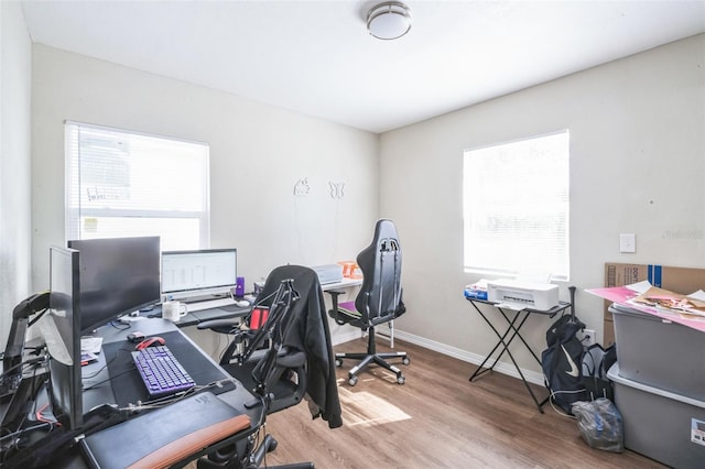 home office featuring wood finished floors, a wealth of natural light, and baseboards