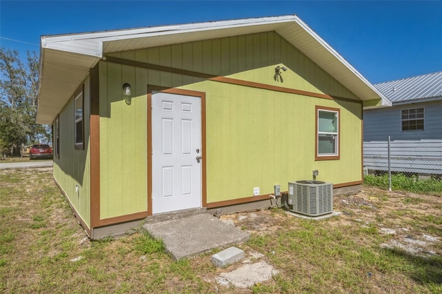 view of outbuilding with central AC unit and fence