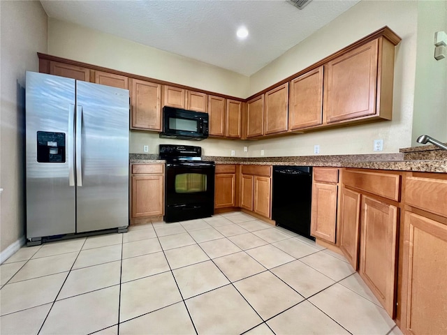 6640 S Goldenrod Rd Unit 118B, Orlando, FL 32822 - kitchen with black appliances, brown cabinetry, and light tile patterned floors