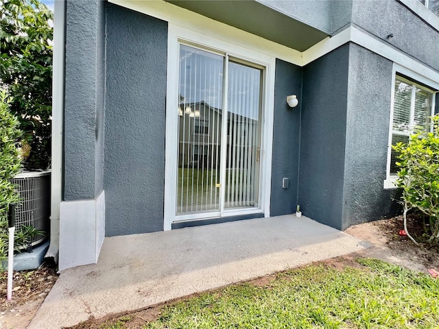 6640 S Goldenrod Rd Unit 118B, Orlando, FL 32822 - doorway to property with stucco siding and central AC unit