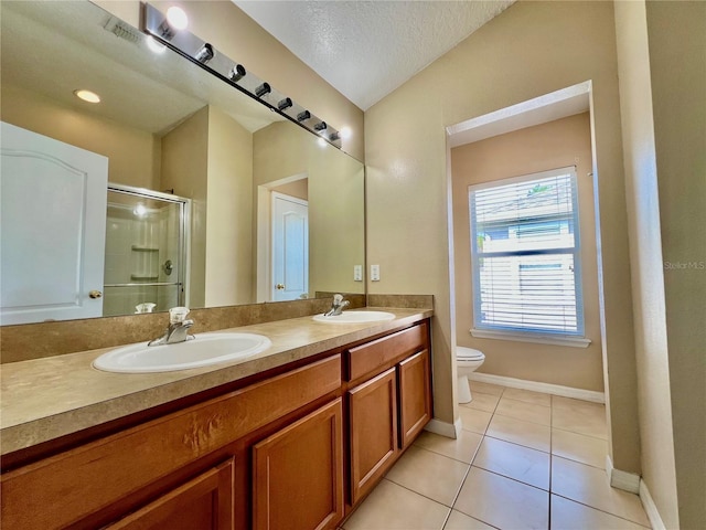 6640 S Goldenrod Rd Unit 118B, Orlando, FL 32822 - bathroom featuring toilet, double vanity, a stall shower, tile patterned flooring, and baseboards