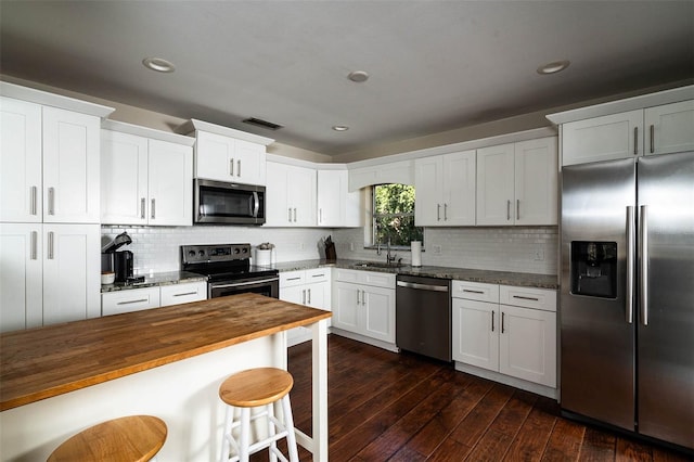 kitchen with white cabinetry, stainless steel appliances, dark hardwood / wood-style flooring, sink, and wood counters