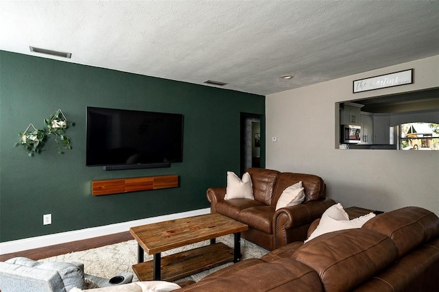 living room with hardwood / wood-style floors and a textured ceiling