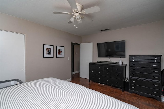 bedroom with dark hardwood / wood-style flooring and ceiling fan