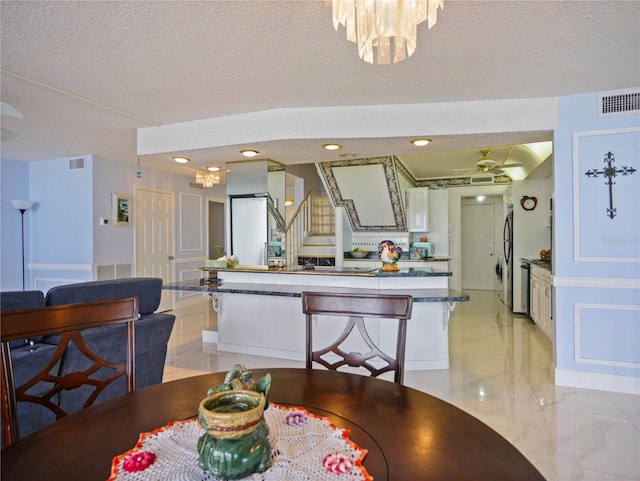 dining area featuring a notable chandelier and a textured ceiling