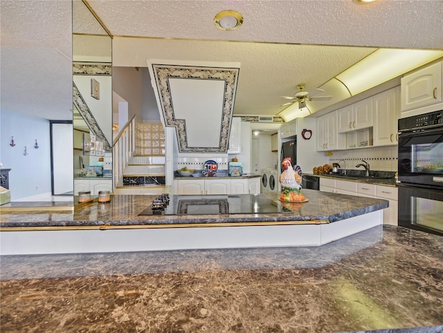 kitchen featuring washer and dryer, a textured ceiling, black appliances, ceiling fan, and sink