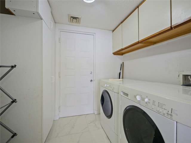 laundry room featuring cabinets and washing machine and clothes dryer