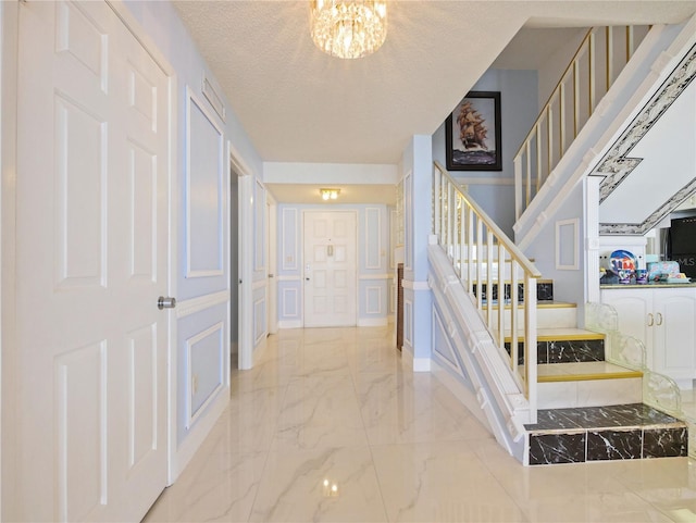 staircase with a textured ceiling and a chandelier