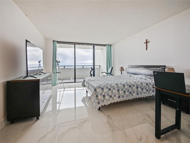 bedroom featuring expansive windows and a textured ceiling