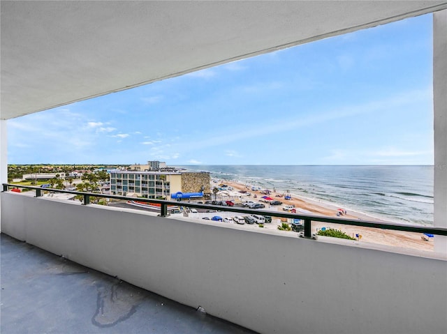 balcony with a water view and a view of the beach