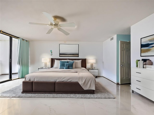 bedroom featuring ceiling fan and a wall of windows