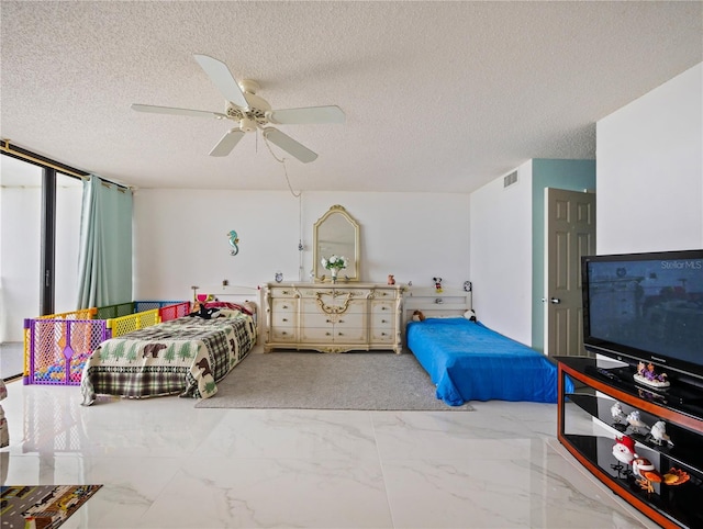 bedroom with ceiling fan and a textured ceiling