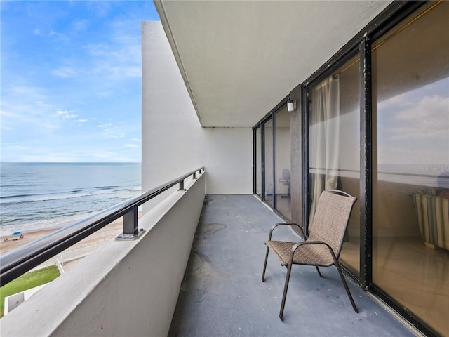 balcony featuring a water view and a view of the beach