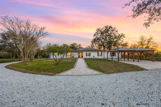 ranch-style house featuring a lawn and a carport