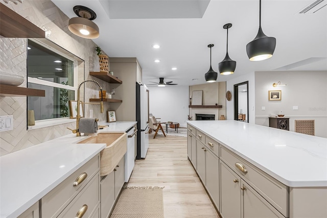 kitchen featuring backsplash, light hardwood / wood-style floors, hanging light fixtures, and high quality fridge