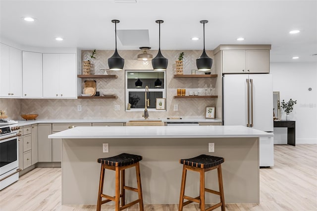 kitchen with a kitchen island, white appliances, and pendant lighting